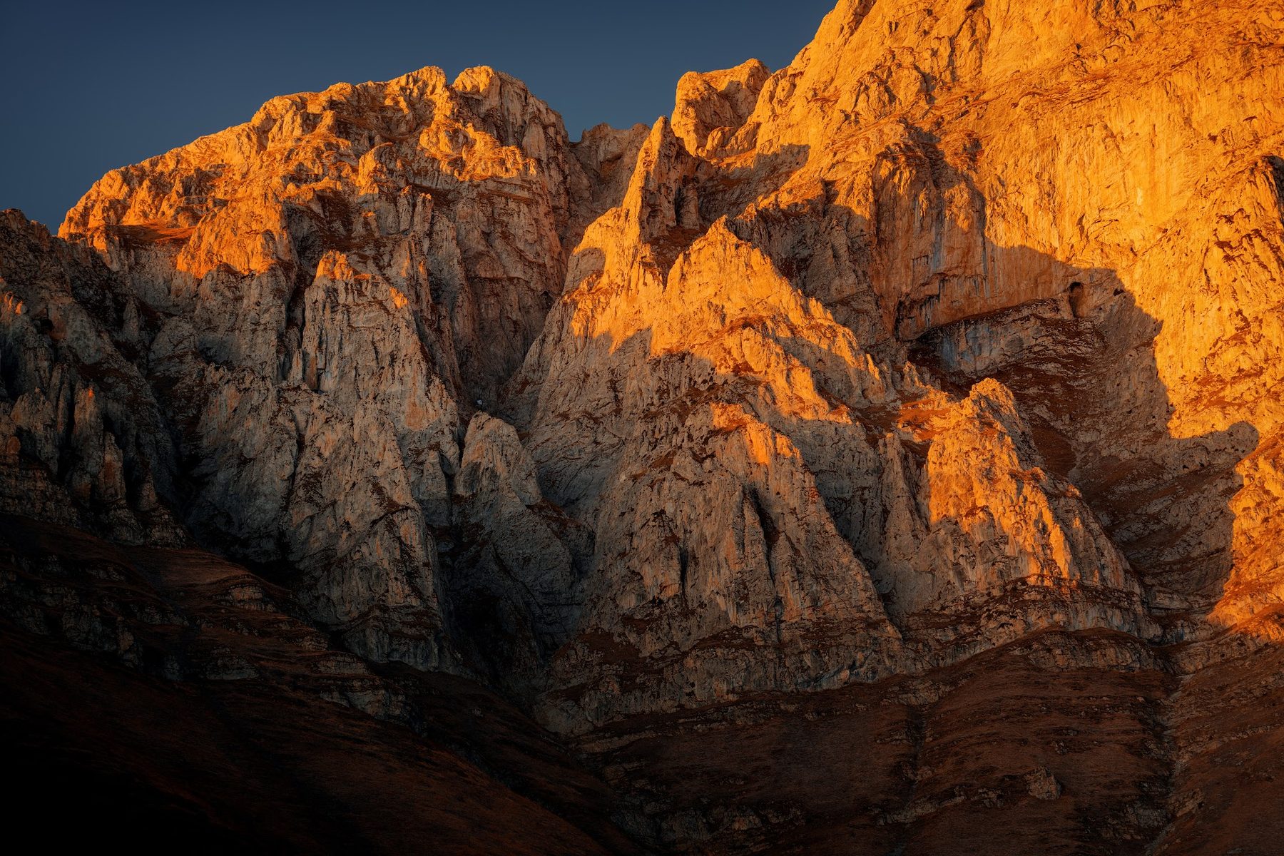 The golden rock face of Mount Khustup at sunset