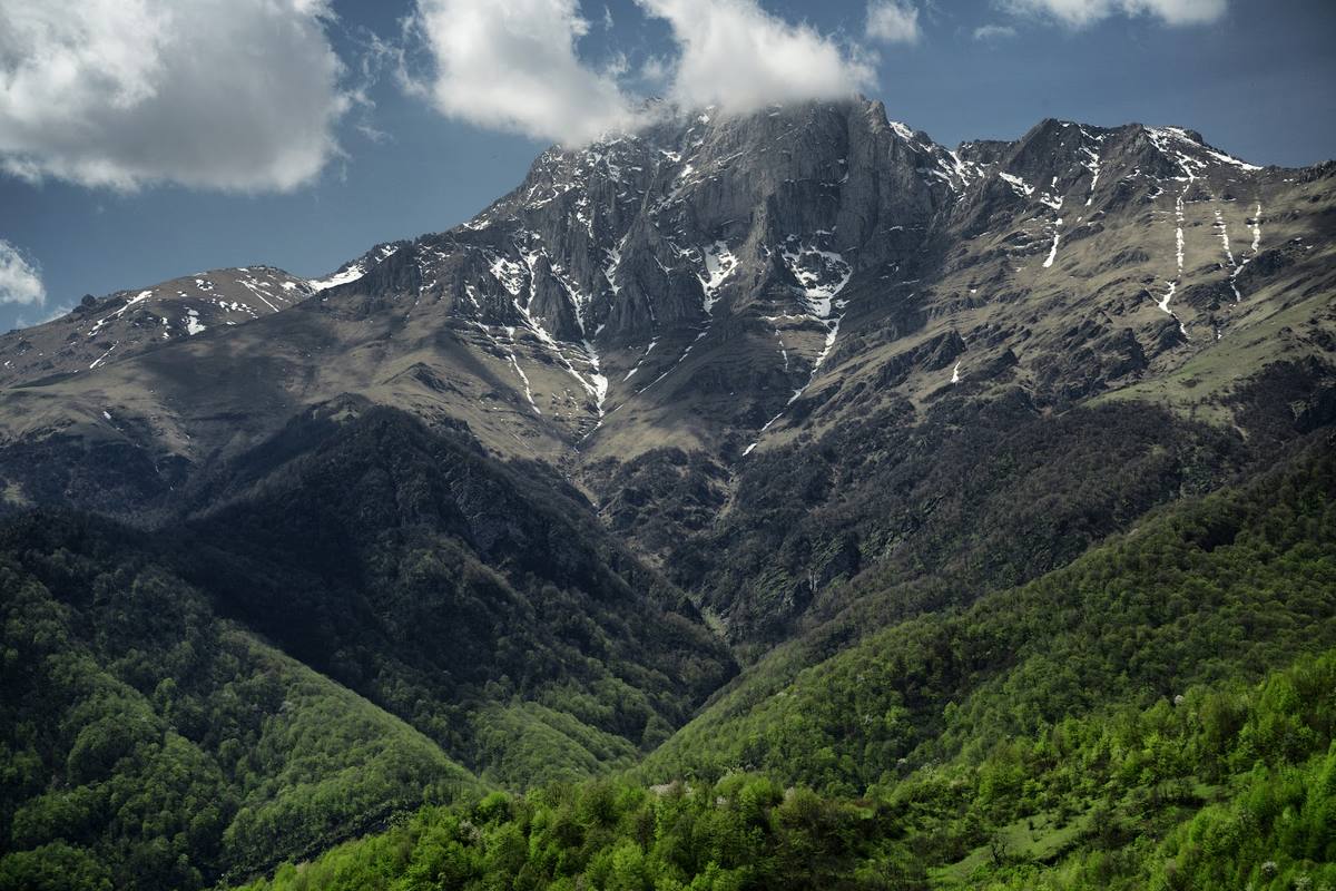 Snowy peaks above green valleys
