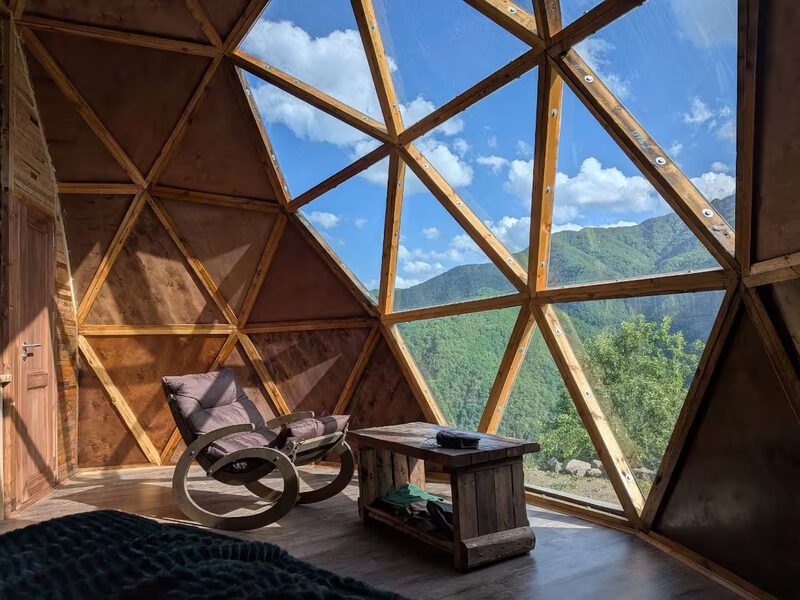 Rocking chair and wooden table beneath the geodesic glass
