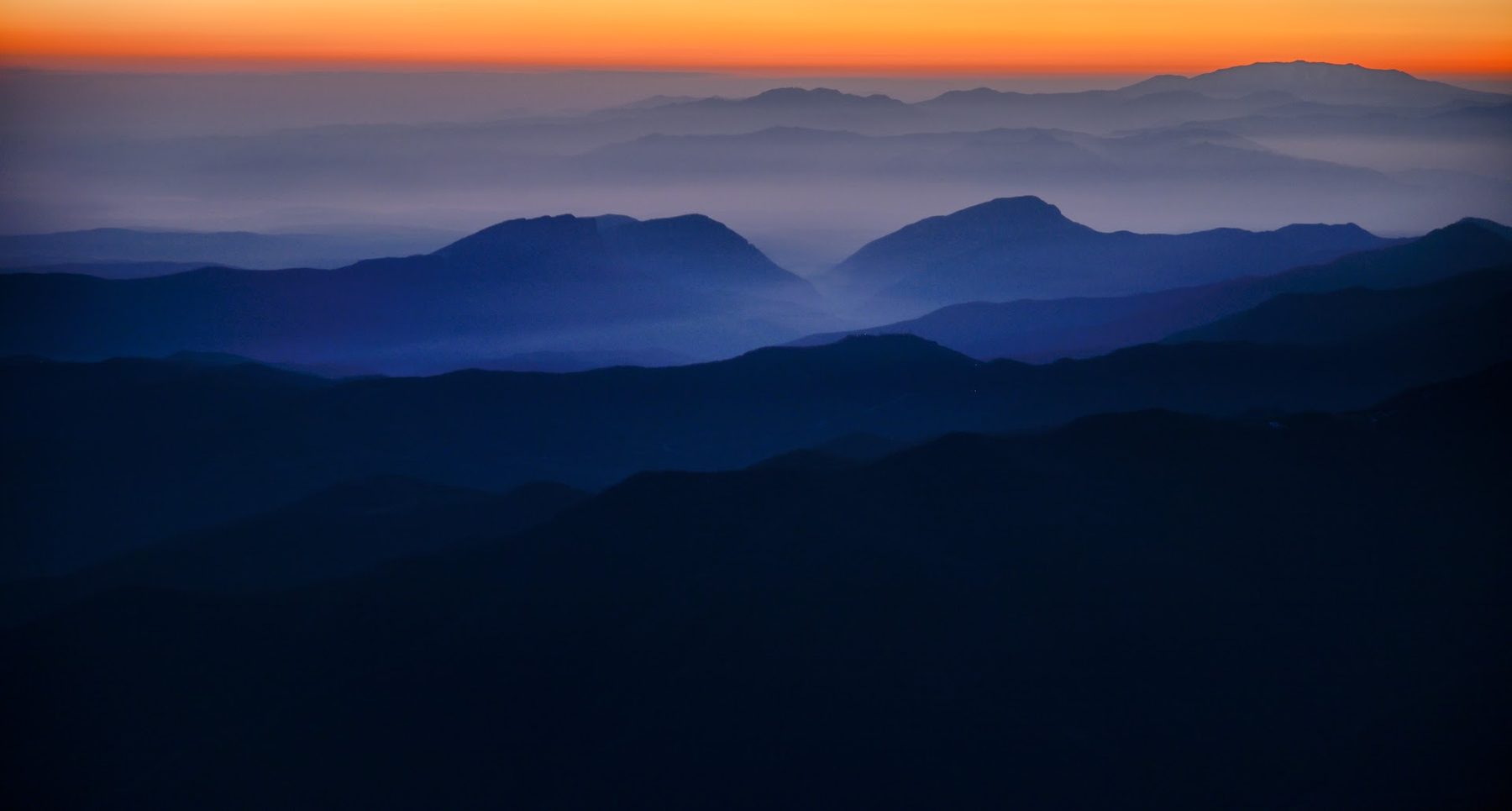 Misty blue valley below the peaks